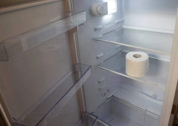 Empty Refrigerator. Toilet Paper in an Empty Refrigerator. White Open Refrigerator. The Concept of a Diet for Weight Loss.