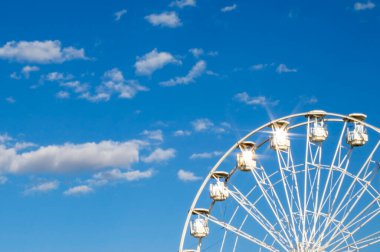 Bir lunaparkta dönme dolaplar mavi gökyüzüne karşı. Bir lunaparkın resmi. Blue Sky 'a Karşı Bir Lunaparkta Dönme Dolap.