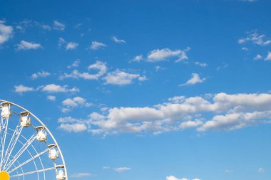 Bir lunaparkta dönme dolaplar mavi gökyüzüne karşı. Bir lunaparkın resmi. Blue Sky 'a Karşı Bir Lunaparkta Dönme Dolap.