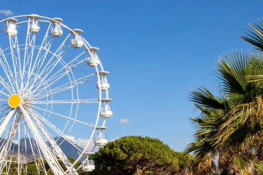 İtalya 'da Blue Sky ve Mountains' a karşı bir lunaparkta dönme dolap. Bir lunaparkta dönme dolaplar mavi gökyüzüne karşı. Bir Eğlence Parkının Resmi.