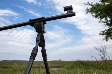 Keskin nişancı tüfeğinin bir parçası gökyüzüne karşı bir bipod üzerinde.