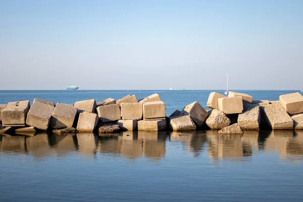 İtalya 'nın güneyindeki Salerno' da şafakta güzel bir manzara. Arka planda pembe ve mavi gökyüzü. İtalya, Salerno 'da, gün batımında Tyrhenian Denizi' nde. Büyük taşlar berrak mavi sulara yansıyor..