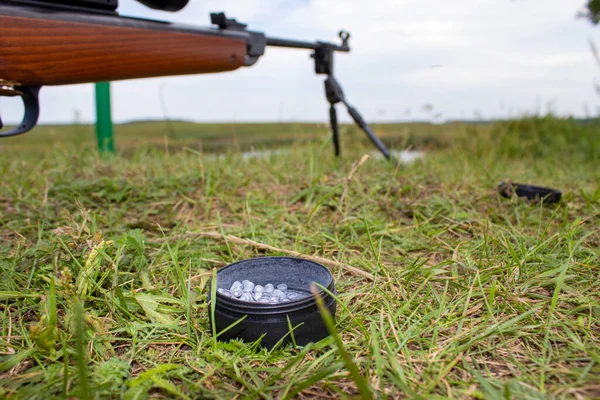 狩りの草を背景に光学的視力で撮影するための空気圧ライフル — ストック写真