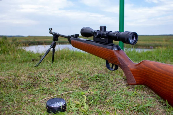 狩りの草を背景に光学的視力で撮影するための空気圧ライフル — ストック写真