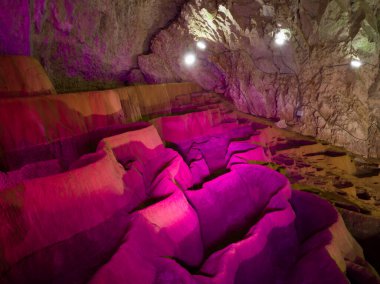 Stopica mağarasının içi, renkli ışıkla aydınlatılmış tufa küvetleriyle Sırbistan 'daki Zlatibor dağının yamaçlarında yer alıyor.