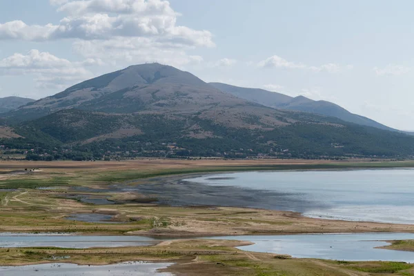 Busko Gölü yaz mevsiminde alçak su seviyeleri ve arka planda dağlarla çevrili.