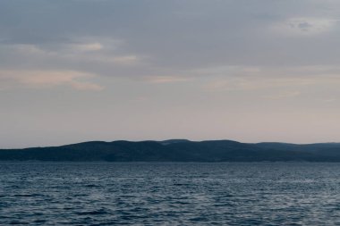 Hırvatistan 'da hava kararırken dalgalı Adriyatik denizi ve Brac adası silüetiyle deniz manzarası
