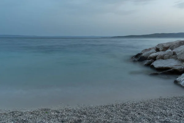 黄昏时遥远的亚得里亚海景 卵石滩和岩石 朦胧的岛屿轮廓 — 图库照片