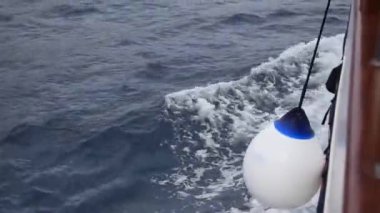 Geminin pruvası yelken açarken dalgaları keser.