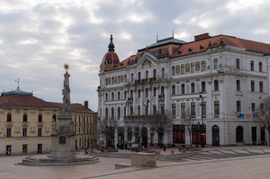 Macaristan 'ın Pecs Avrupa kentindeki Szechenyi meydanındaki güzel dekore edilmiş belediye binası ve Kutsal Üçlü heykel.