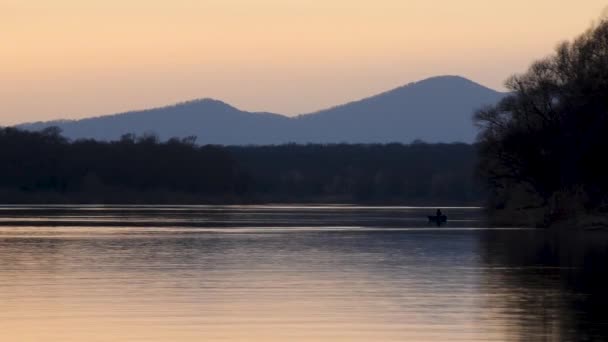 Чоловік Човном Ловить Рибу Річці Сутінках Безлистяні Ліси Далеку Гору — стокове відео