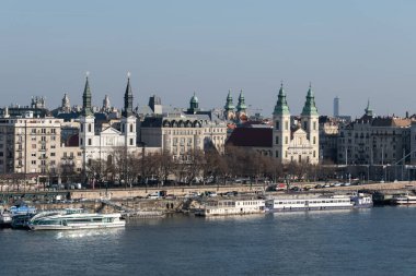 Macaristan 'ın Budapeşte kentindeki Tuna Nehri kıyısındaki ortodoks ve katolik kilisesiyle şehir manzarası
