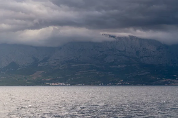 从亚得里亚海中消失在克罗地亚海岸的乌云中的比奥科沃山脉 — 图库照片