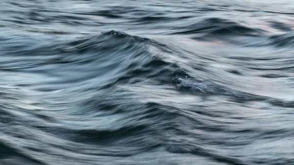 長時間露光とモーションブラー効果で絹のような表面を持つ風の波状乱流水の抽象的な風景 — ストック写真