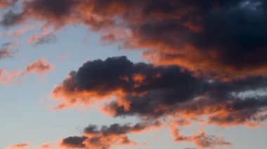 Gün batımında bulutların üzerinde parlayan portakal.