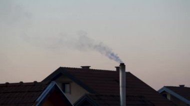 Evin bacasından çıkan dumanlar kış boyunca merkezi ısıtmaya neden olur.