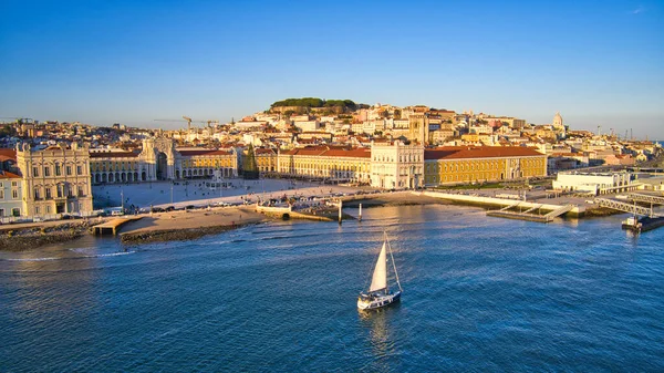 Portekiz, Lizbon 'daki ticaret meydanının insansız hava aracı görüntüsü. Kış batımı. Tagus Nehri 'nde yelkenli tekne.