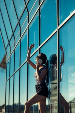 Mağaza vitrininin yanında kısa şortlu güzel bir kız..