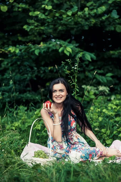 森林里的女人在野餐时吃葡萄 — 图库照片