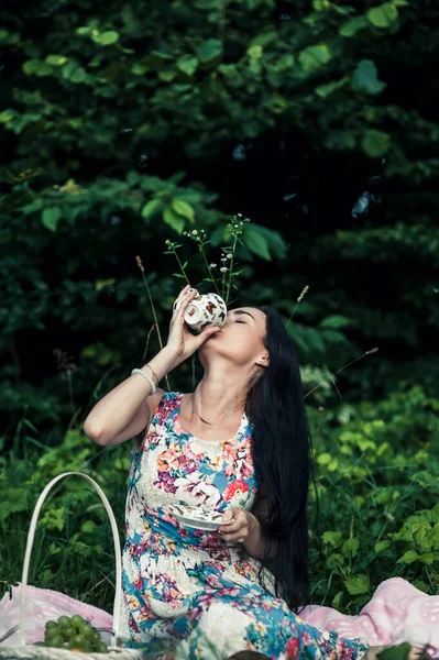 女の森の中でピクニックブドウを食べる — ストック写真