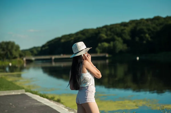 川のそばで電話で話してるクールな女の子 — ストック写真