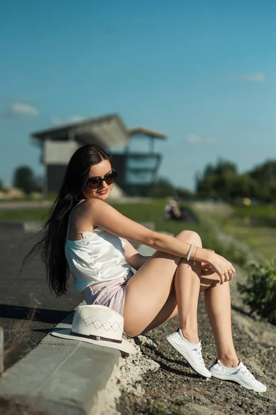 清凉的姑娘坐在河边的公园里休息 — 图库照片
