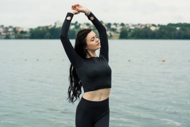 Spor salonundaki esmer kız gölün kenarında..