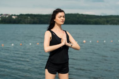 Spor kıyafetleri içinde gün batımına karşı spor egzersizleri yapan çekici bir kadın. Aktif genç kız