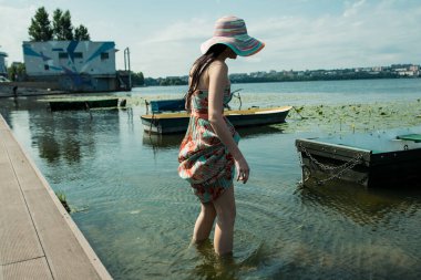 Göldeki bir teknede esmer bir kız. Güneşli bir gün.