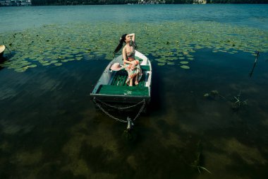 Göldeki bir teknede esmer bir kız. Güneşli bir gün.
