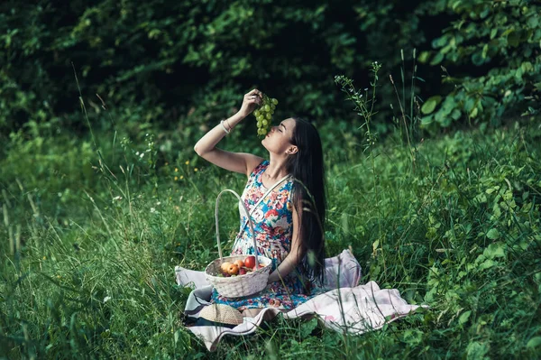 一个女孩在森林里野餐 一个漂亮的女人吃水果 — 图库照片