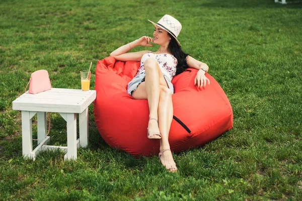 Güzel kız su kenarındaki parkta meyve suyu içiyor..