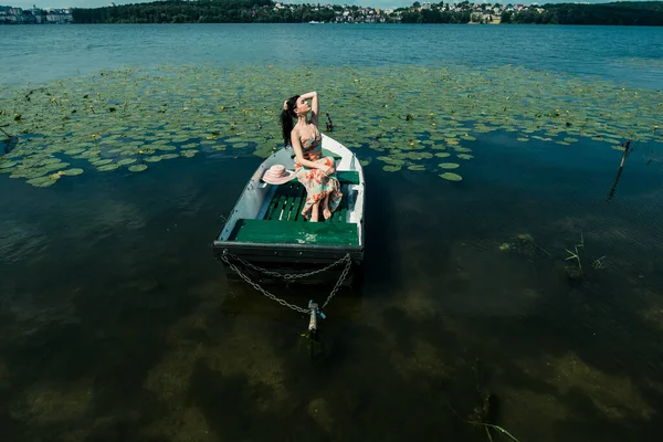 湖の上のボートの中のブルネットの女の子 晴れた日 — ストック写真