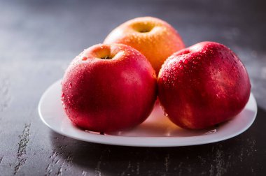 Kırmızı elma yaklaş. Siyah desenli taze kırmızı elma. Elma ve su damlası. metin alanı. Vejetaryenler için sağlıklı yiyecekler.
