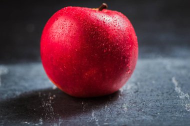 Kırmızı elma yaklaş. Siyah desenli taze kırmızı elma. Elma ve su damlası. metin alanı. Vejetaryenler için sağlıklı yiyecekler.