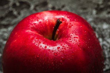 Kırmızı elma yaklaş. Siyah desenli taze kırmızı elma. Elma ve su damlası. metin alanı. Vejetaryenler için sağlıklı yiyecekler.