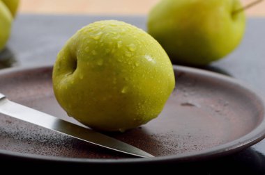 Meyveleri dilimliyorum. Masada sarı sulu elmalar var..