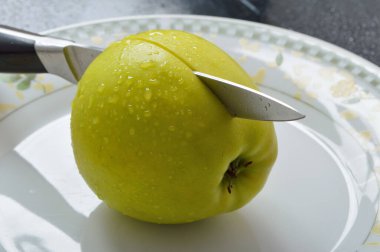 Meyveleri dilimliyorum. Masada sarı sulu elmalar var..