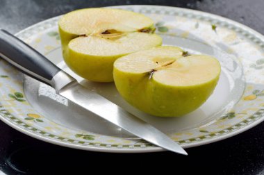 Meyveleri dilimliyorum. Masada sarı sulu elmalar var..