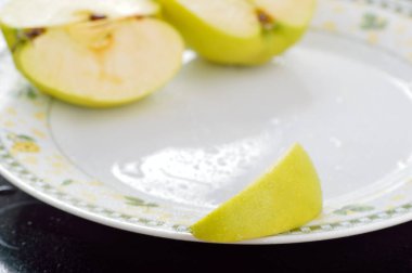 Meyveleri dilimliyorum. Masada sarı sulu elmalar var..