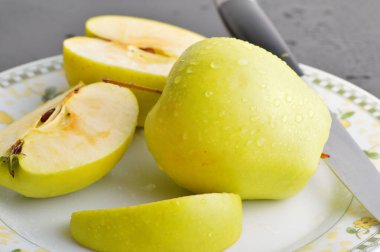 Meyveleri dilimliyorum. Masada sarı sulu elmalar var..