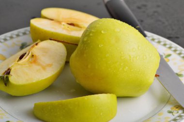 Meyveleri dilimliyorum. Masada sarı sulu elmalar var..