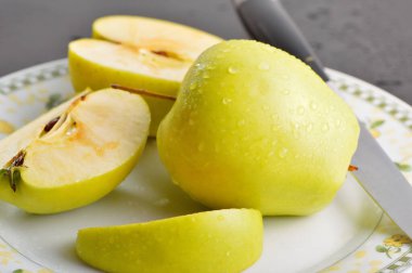 Meyveleri dilimliyorum. Masada sarı sulu elmalar var..