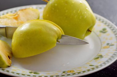 Meyveleri dilimliyorum. Masada sarı sulu elmalar var..