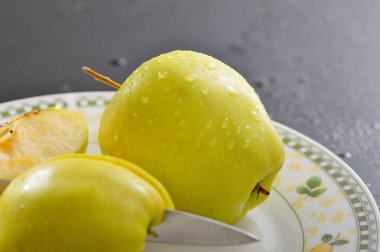 Meyveleri dilimliyorum. Masada sarı sulu elmalar var..