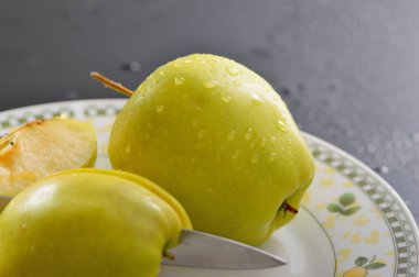 Meyveleri dilimliyorum. Masada sarı sulu elmalar var..