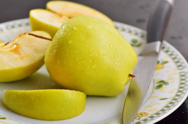 Meyveleri dilimliyorum. Masada sarı sulu elmalar var..