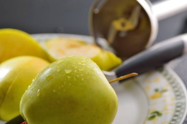 Meyveleri dilimliyorum. Masada sarı sulu elmalar var..