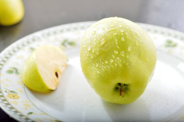 Meyveleri dilimliyorum. Masada sarı sulu elmalar var..