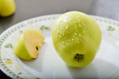 Meyveleri dilimliyorum. Masada sarı sulu elmalar var..